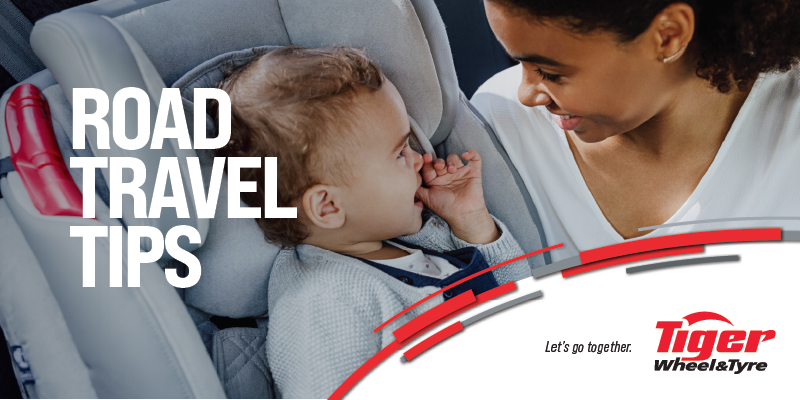 a woman putting a baby in a car chair